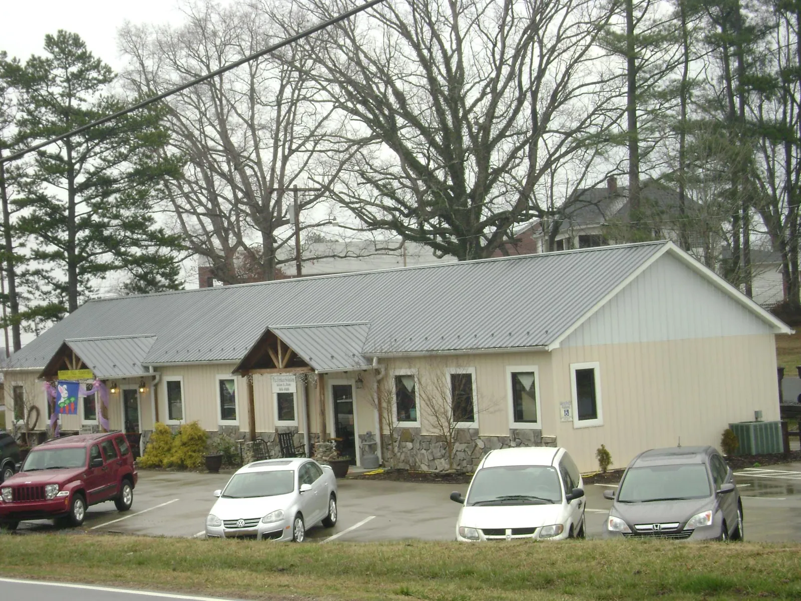 Gray metal roof with timber entry brackets on a small commercial building in Glendale
